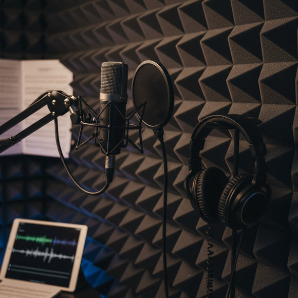 Detailed shot of high-density foam tiles, a studio microphone, and headphones—emphasizing the importance of acoustic foam.